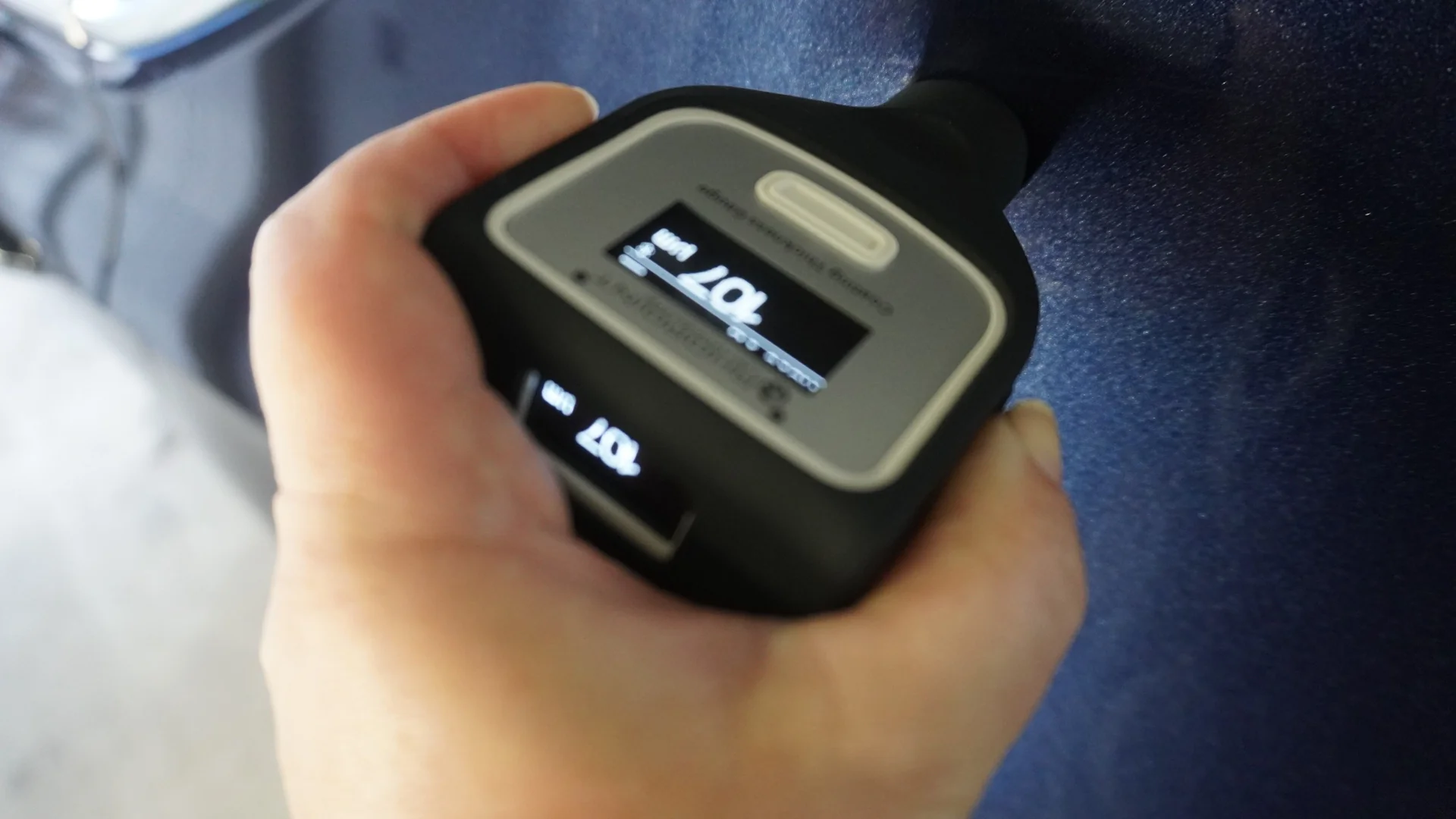 Lackschichtmessung mit einem digitalen Messgerät an dunklem Fahrzeuglack